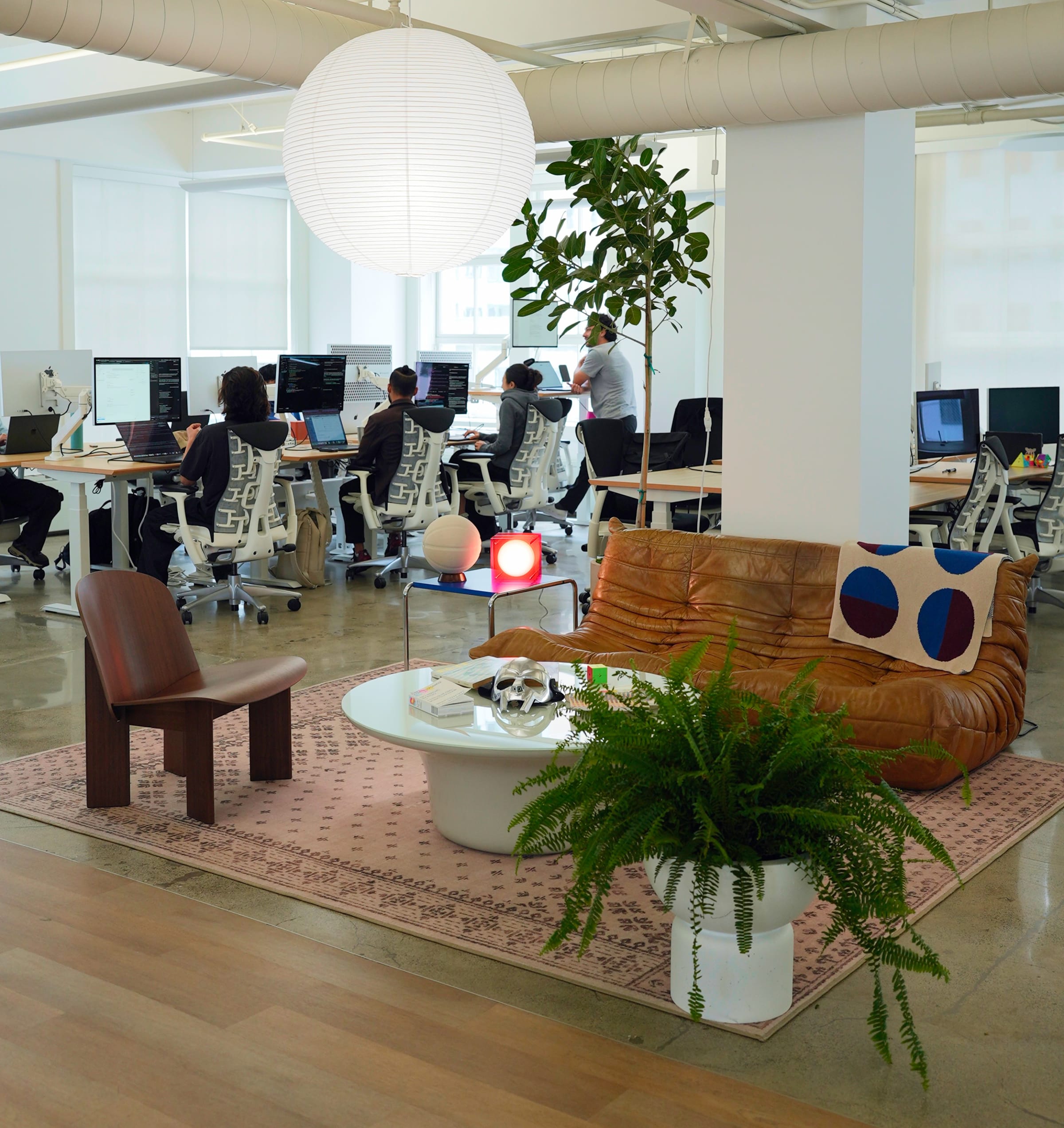 The Cohorva office floor, with the team at their desks beside the lounge area