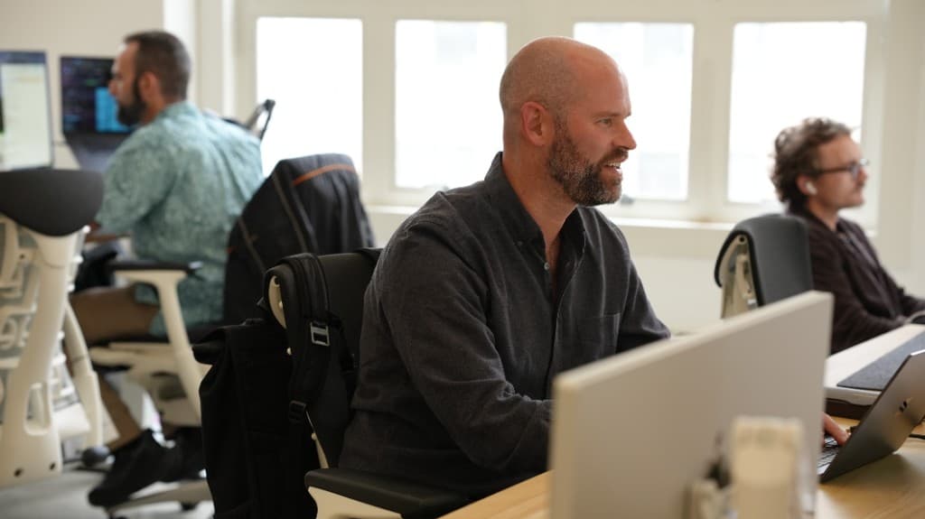 Cohorvaers working side by side on the open office floor